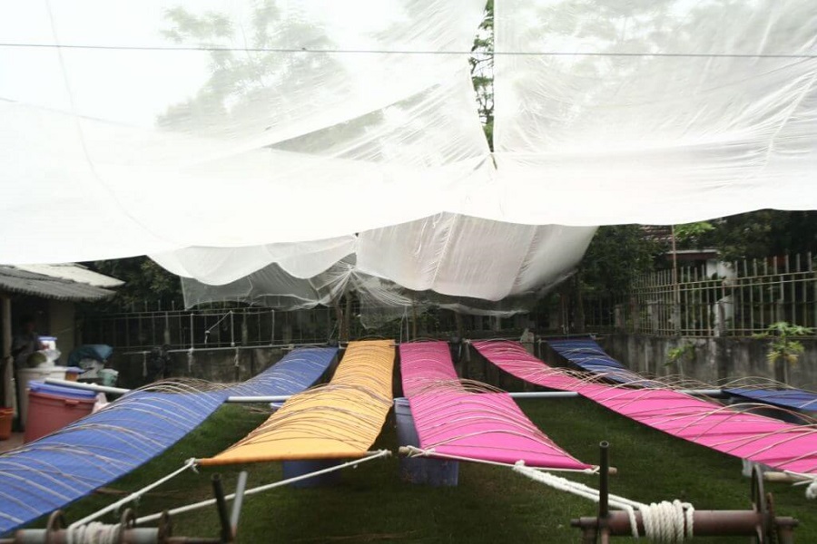 The artisan dries the fabric after dyeing