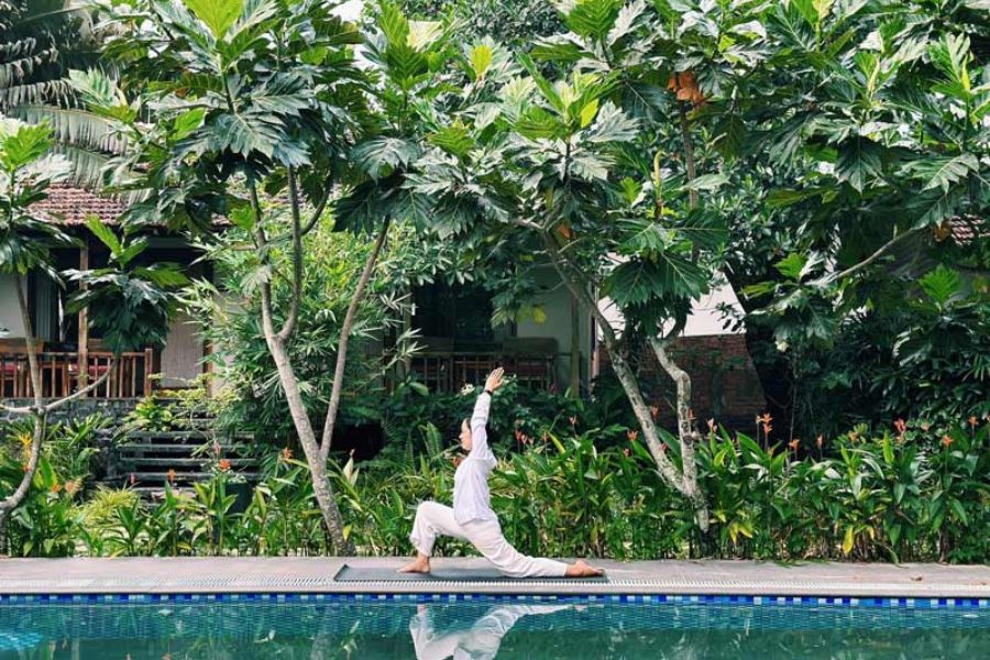 An outdoor yoga session surrounded by nature at a peaceful wellness retreat in Vietnam