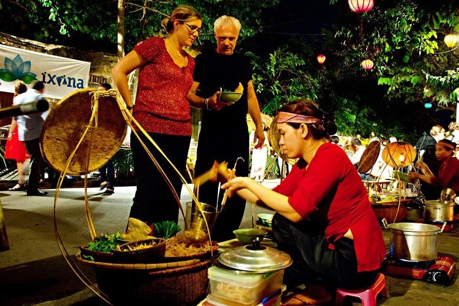 Tourists try local cuisine in the night market