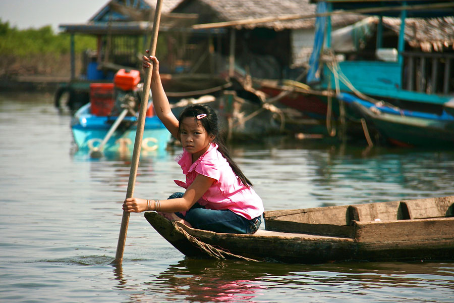 A little girl rowing a boat at Tonle Sap Lake 