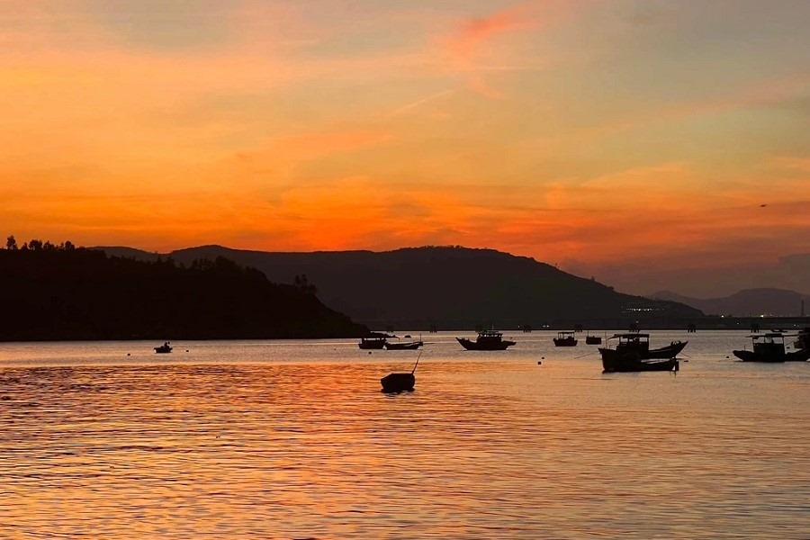 Faint outlines of boats on the horizon at dusk