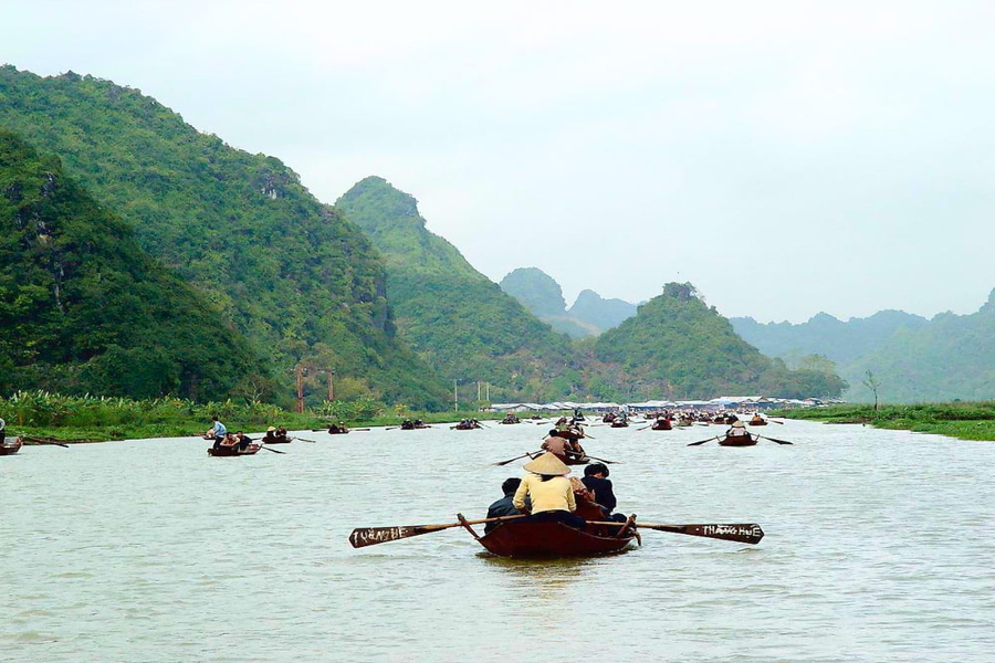 Before reaching the entrance, you will sit on a boat and go along stream. Source: Xanh SM