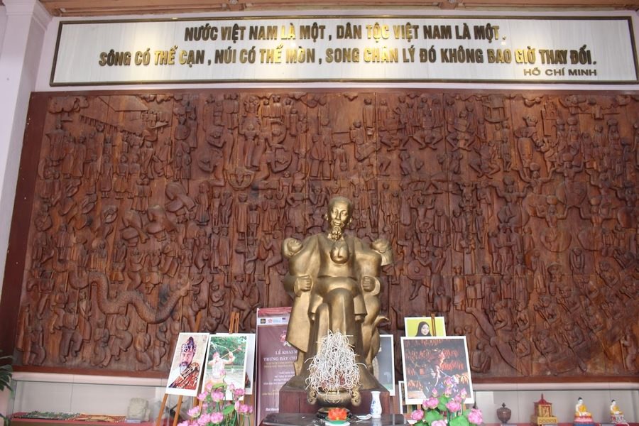 The wooden relief and statue of Uncle Ho embracing three children