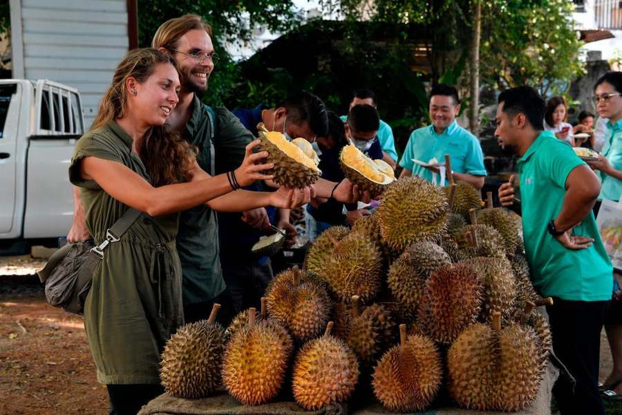Many foreign tourists enjoy this strongly aromatic fruit. Photo: The Sun