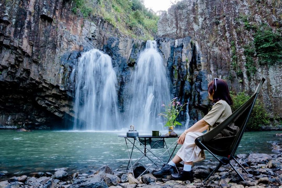 A girl enjoys a tranquil moment by Vuc Hom Waterfall 