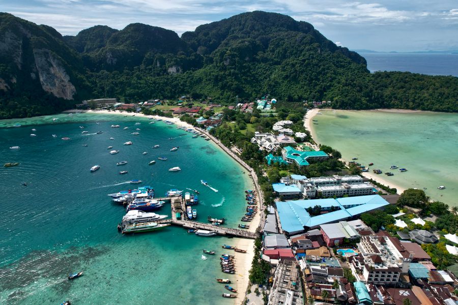 A stunning aerial view of Tonsai Village, Phi Phi Islands, featuring vibrant turquoise waters and lush green hills