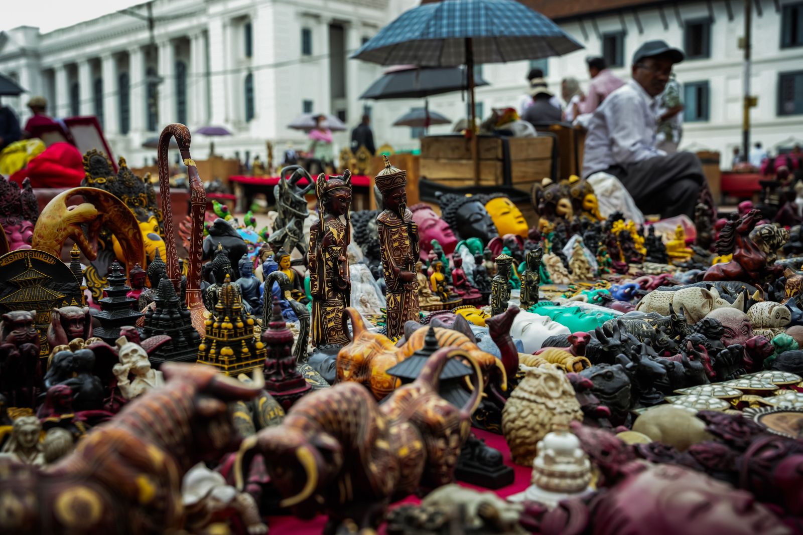 Colorful market stalls display various religious artifacts and handicrafts
