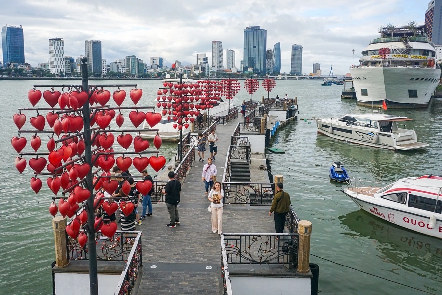 A romantic stroll on Da Nang’s Love Bridge, surrounded by heart-shaped lanterns and city views