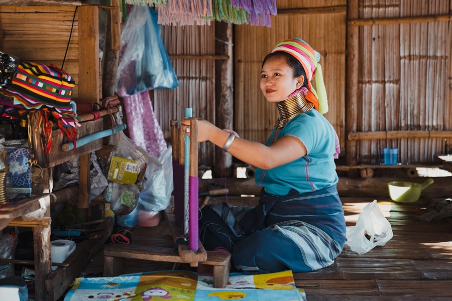 A Long Neck Karen woman weaving by hand