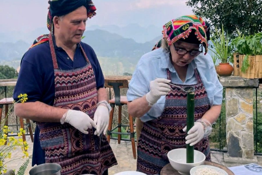 Western tourists experience making sticky rice in bamboo tubes