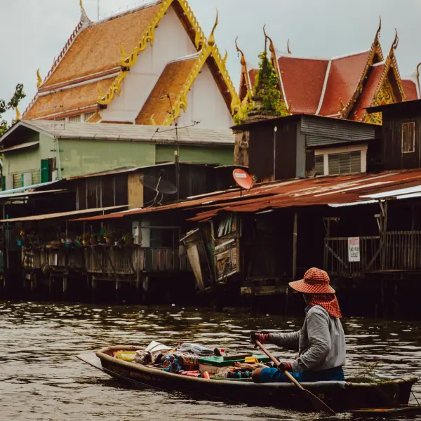Longtail boat passing Wat Arun at sunset